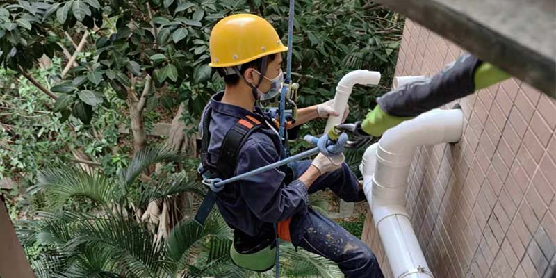 海门区高空作业师傅正在维修外墙排水管